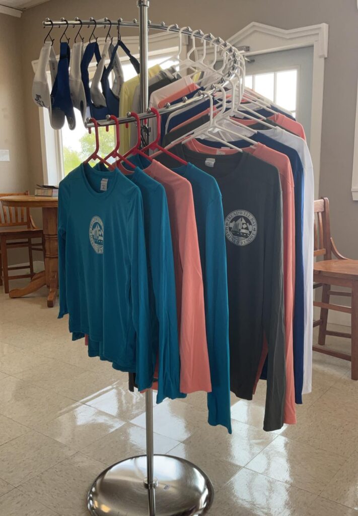 A rack of shirts and shoes hanging on the floor.